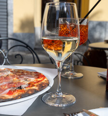 Glass of cold dry white wine served outdoor in cafe in Bellagio, Como lake, Italy
