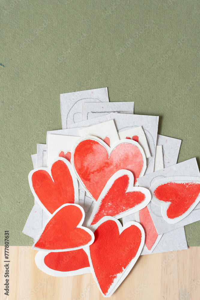 Wall mural heaping pile of paper hearts on rough green paper and wood