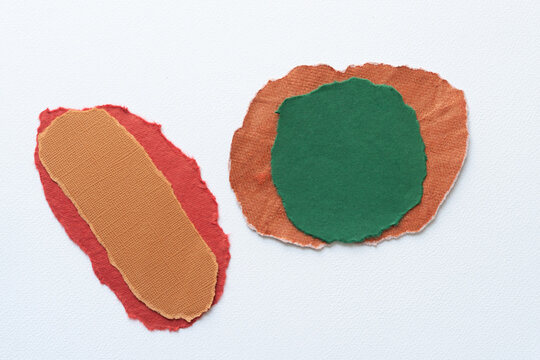 roundish paper shapes with decorative torn edges on blank paper