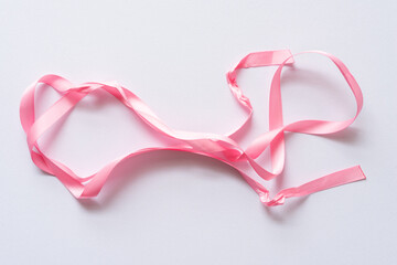 unraveled pink ribbon on paper