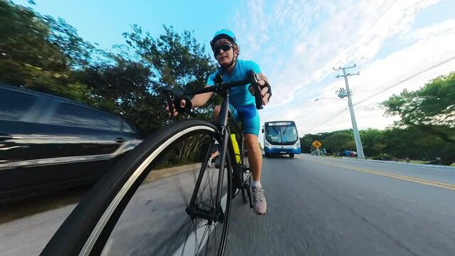 Man in blue equipment cycling in the urban area in dangerous proximity of all kind of transport