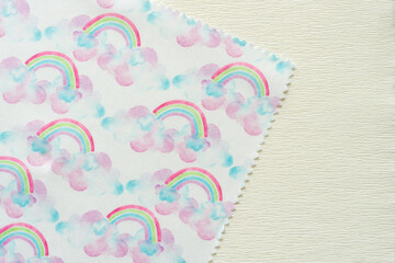 corner of fabric doily with rainbows and clouds print pattern on crepe paper - obrazy, fototapety, plakaty
