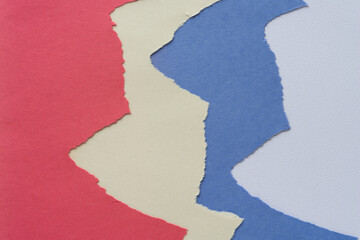 old, faded red, white, and blue construction paper sheets with torn or ripped edge arranged so as to form an abstract background
