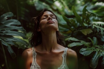 Serene woman in greenery, closed eyes, deep breath, connection with nature, peaceful moment, spiritual awakening, tropical forest.

