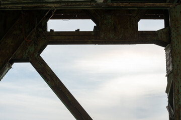 bridge structure in near silhouette on a bright cloudy sky