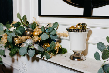 Elegant Holiday Mantel Decor with Festive Greenery. A classic holiday mantelpiece adorned with lush...