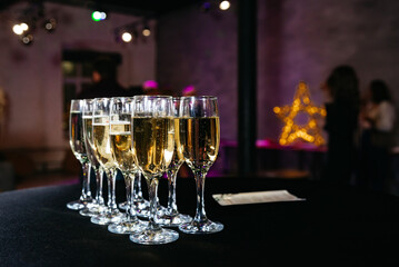 Champagne Toast Ready for Celebration Event. Glasses of sparkling champagne lined up on a dark...