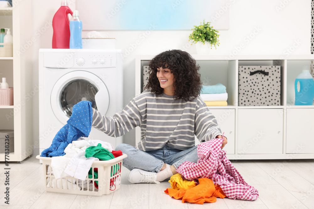 Canvas Prints Happy woman with laundry near washing machine indoors