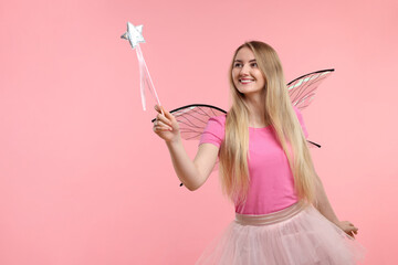 Beautiful girl in fairy costume with wings and magic wand on pink background, space for text