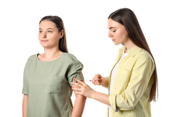 Woman giving insulin injection to her diabetic friend on white background