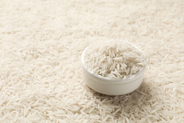 Bowl on raw basmati rice, closeup view. Space for text