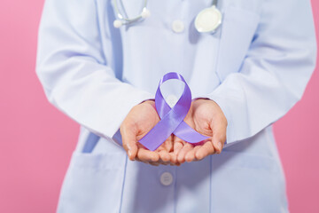 Prostate cancer awareness. Close up medical doctor holding ribbon over pink background isolated....