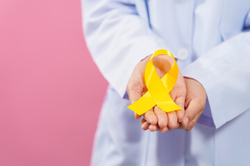 Medical doctor holding yellow ribbon isolated on pink background, Yellow September, Suicide...