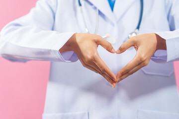 Heart shape, Close up female medical doctor isolated on pink background.