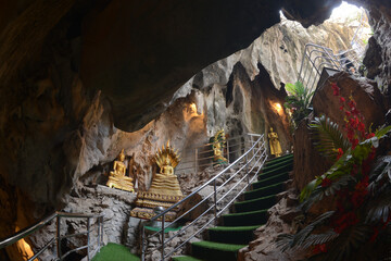 Buddha statues in various postures Enshrined in the famous Tham Khao Yoi Temple. And there are beautiful stalagmites and stalactites. Located at Petchaburi Province in Thailand. - obrazy, fototapety, plakaty