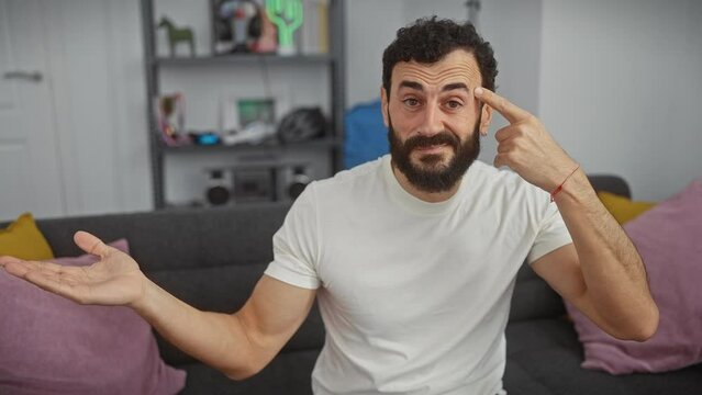Middle-age man, puzzled and irked at home, points to forehead in a classic 'think about it' gesture. wearing a white t-shirt, he shows annoyance while revealing an open palm ad space.