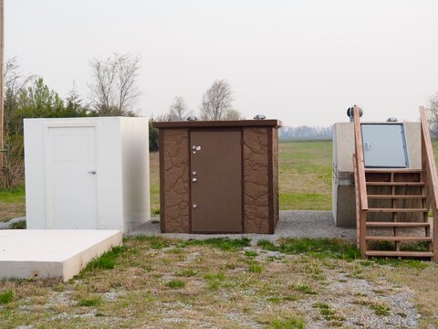 Three tornado shelters. The one on the right is buried, the other two are above ground. 