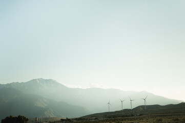 California desert wind turbines illuminated on a mountain background with sunlight near Palms...