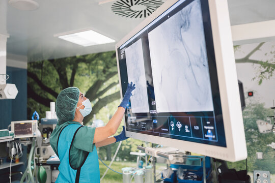 Surgeon looking at scans on monitor screen