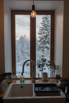 view of kitchen sink with window and snow covered tree outside.  