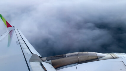  Stormy skies loom around the airplane wing in flight.