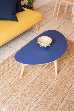Blue coffee table with a bowl on top in a living room