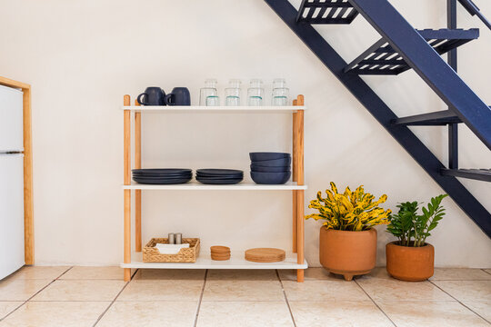 Wooden shelf with crystal glasses and blue ceramic plates