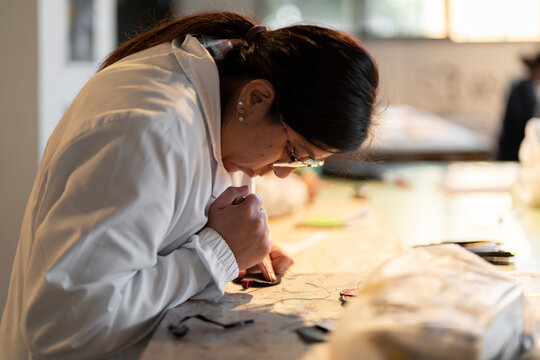 Focused woman working at table in recycling leather fashion lab