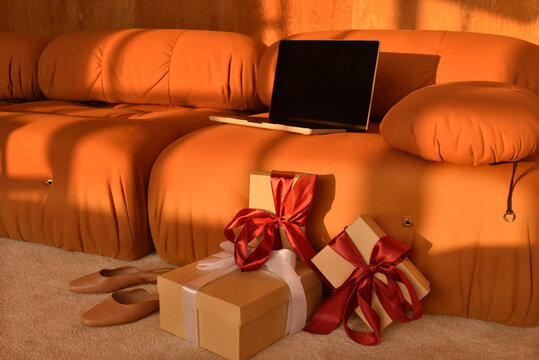 Laptop and gifts are on a coach with gifts