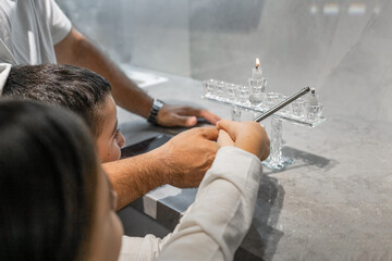 Family Hanukkah Celebration. Father and Children Light Hanukkah Candle
