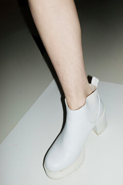 Woman with shin hair wearing boots. Image normalizing female body hair