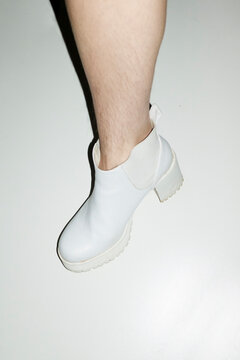 Woman with shin hair wearing boots. Image normalizing female body hair
