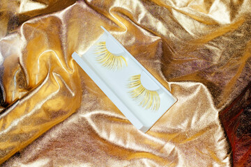 Still life image of shiny metallic golden beauty eyelash extensions