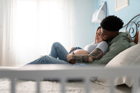 Pregnant Couple lying in the bedroom