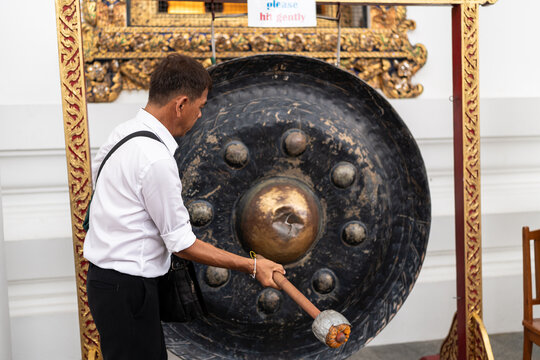 Man hitting a gong.