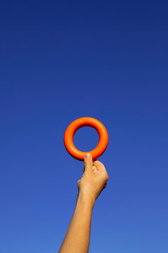 Hand holding a red torus and blue sky background