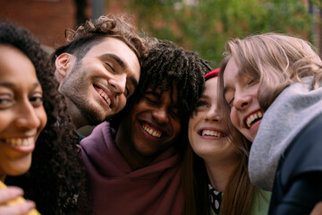 Five young adults embrace outdoors