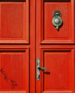 Red textured door with old vintage handles