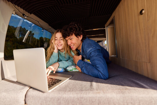 Young couple watching film in camper
