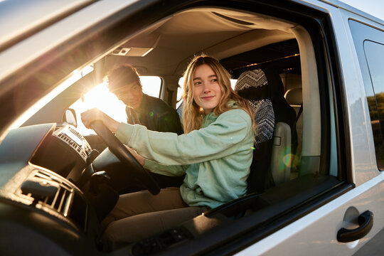 Happy young woman driving caravan