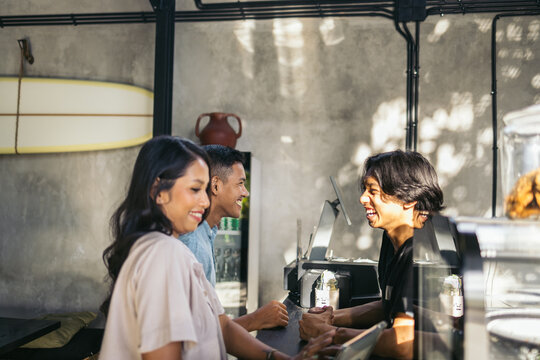 Customers Customers ordering at the counter of a cafe