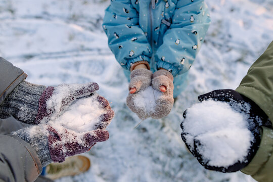 hands of a woman and her children holding snow