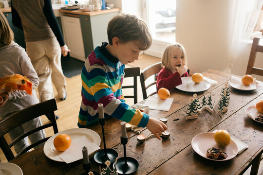 boy lighting candle on holiday table 