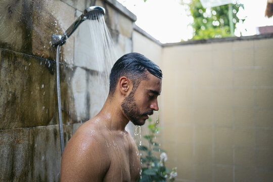 Man taking a shower in an open bathroom