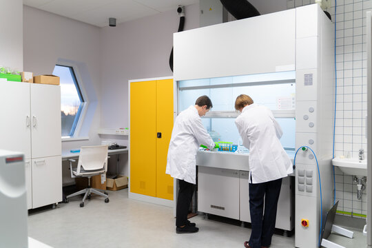 Researchers Working Together At Chamber In Lab