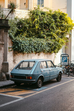 Old blue italian car parked on the street in Italy