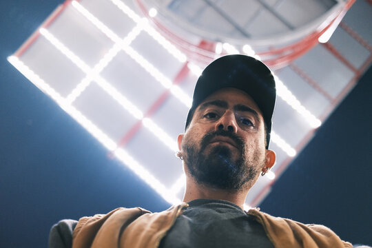 man posing for camera at night with lights out of focus 