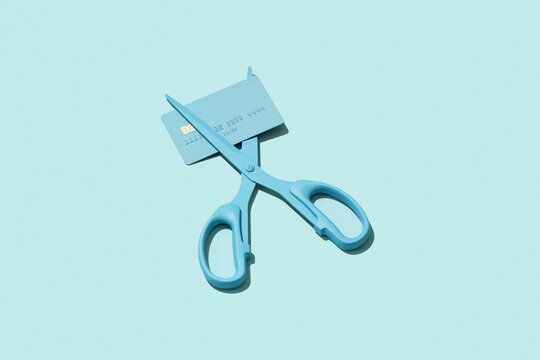 Scissors cutting debit / credit card. Reduce / pay off debt concept.