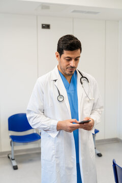 Portrait of a male doctor using mobile phone in the hospital.