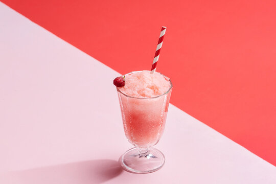 Glass of bright pink raspberry drink with crushed ice